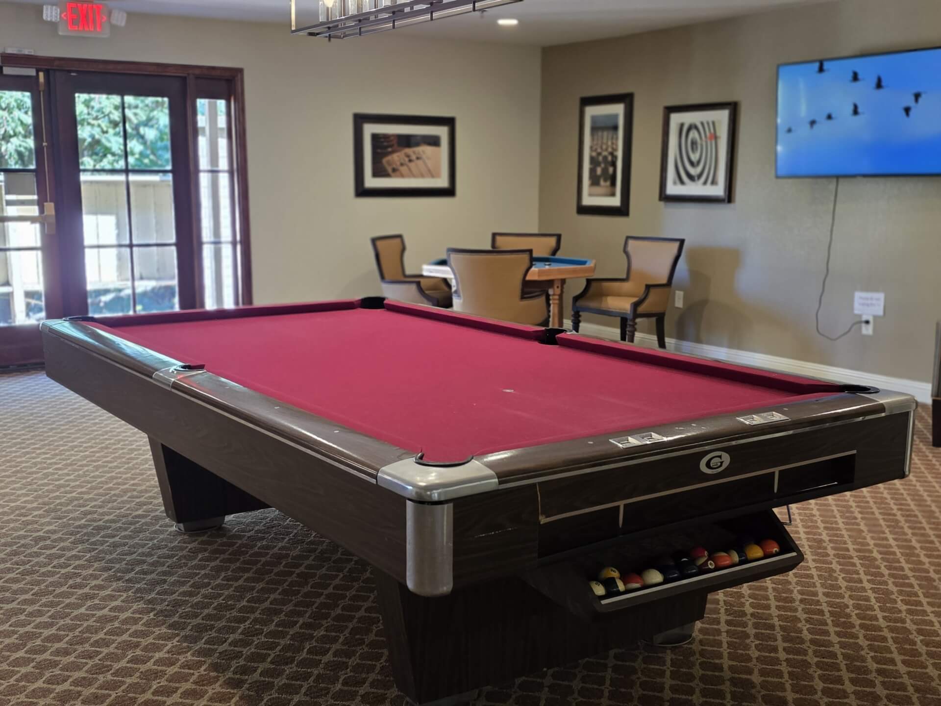 Red pool table in a recreational room.