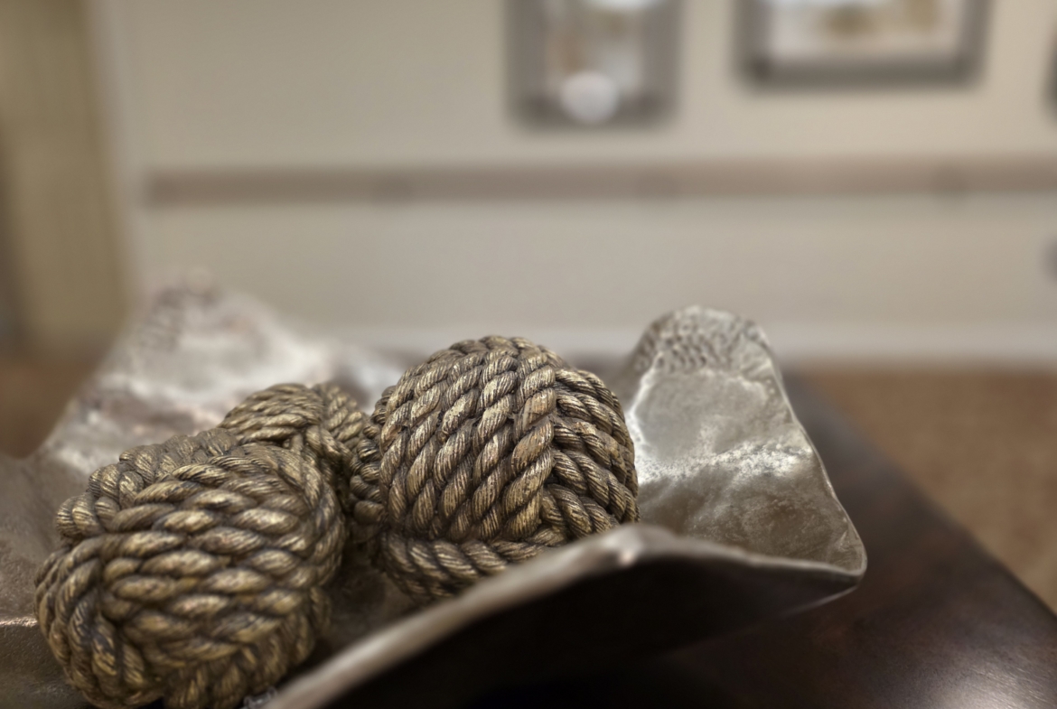 Decorative rope balls in a metal bowl.