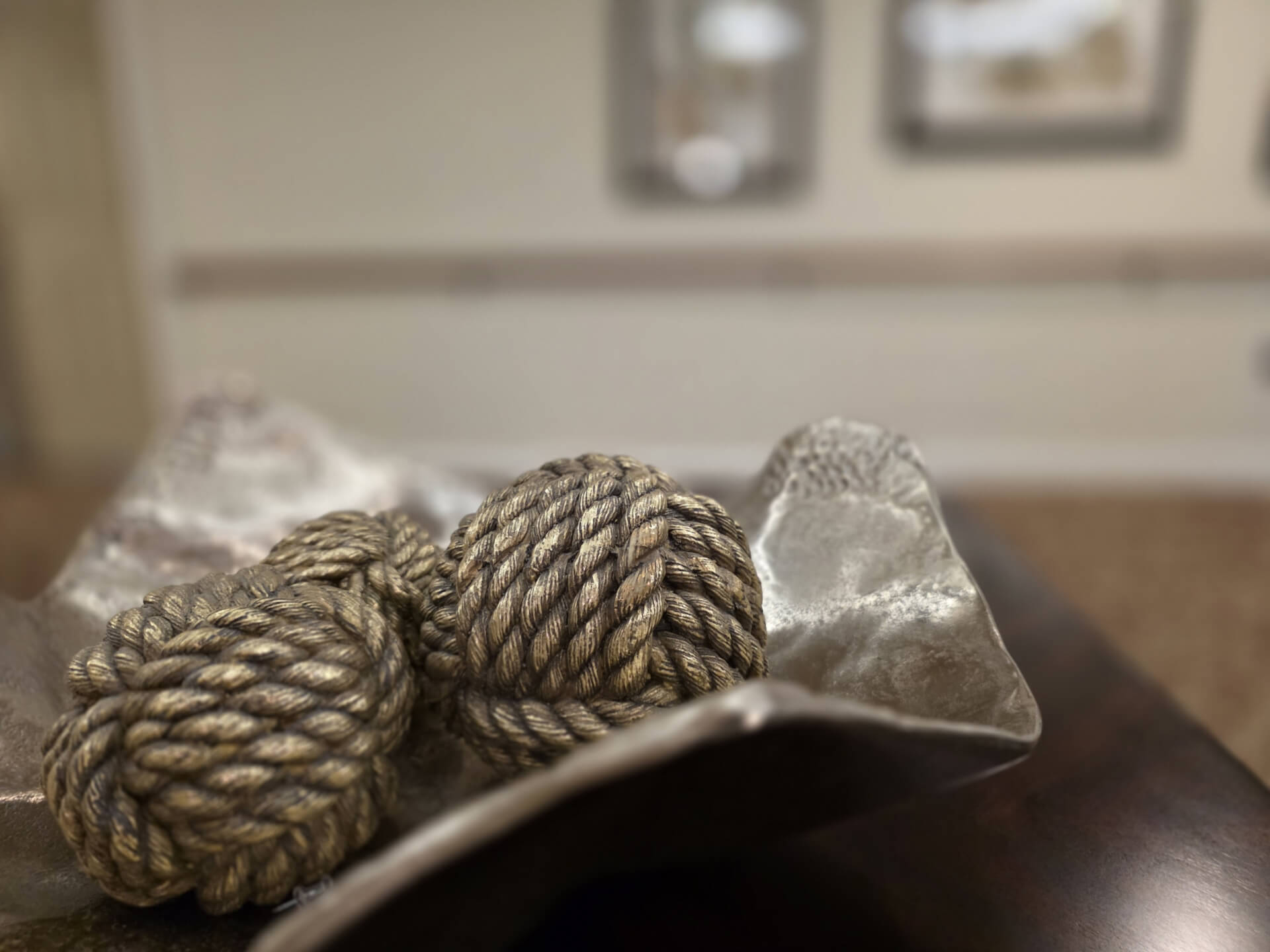 Decorative rope balls in a metal bowl.