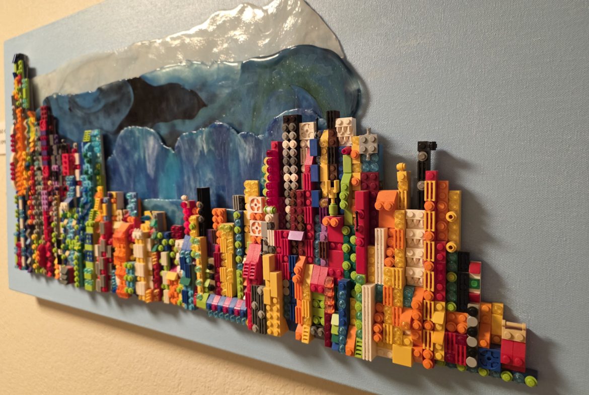 Colorful Lego cityscape on blue canvas.