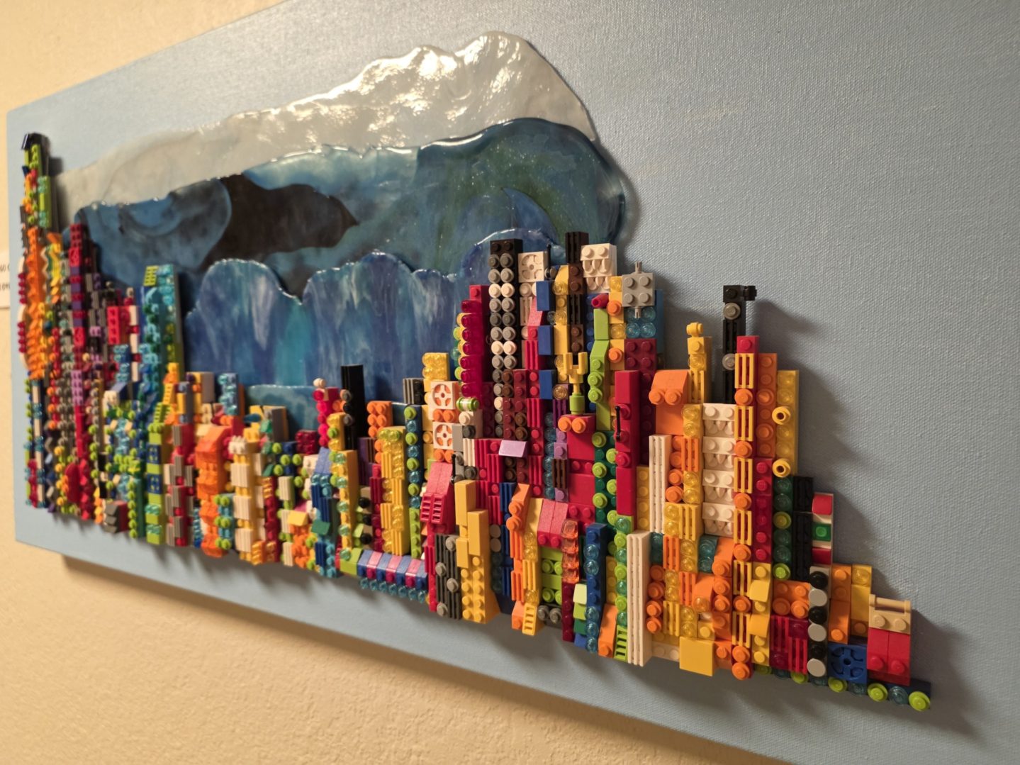 Colorful Lego cityscape on blue canvas.