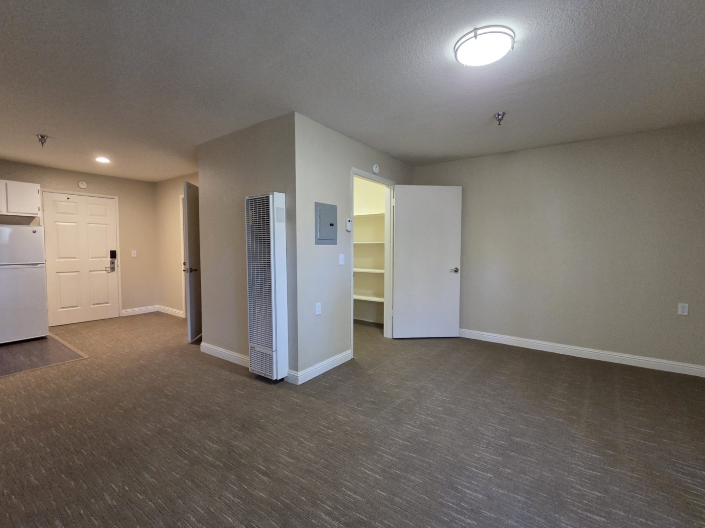 Empty room with open closet and door.